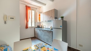 Una cocina compacta con armarios de madera, un lavamanos y un refrigerador.
