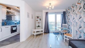 En moderne lejlighed med køkken, spiseplads og en balkon.