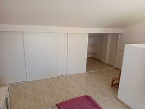 A room with a large wardrobe, a small wooden chair, and a red rug. - Triplex del Duque (Fañabe)