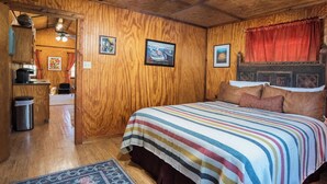 A wooden-paneled room with a large bed, a small desk, and a trash can. - 1906 Estate For 21 Guests W/pool,hot Tub (Comfort)