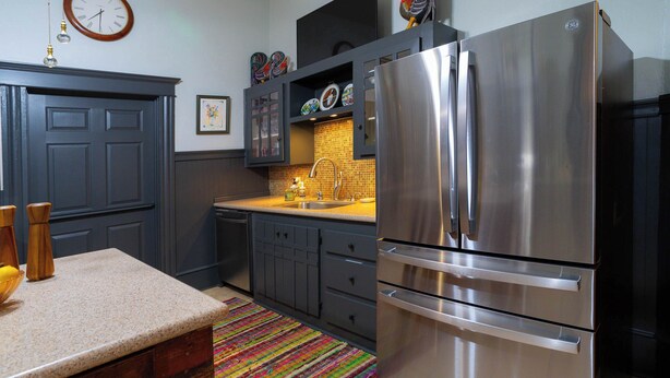A kitchen with dark cabinets, a stainless steel refrigerator, a colorful rug, and a clock on the wall. - 1906 Estate For 21 Guests W/pool,hot Tub (Comfort)