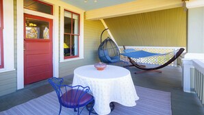 A covered outdoor seating area with a round table and chairs, a hanging chair, and a hammock. - 1906 Estate For 21 Guests W/pool,hot Tub (Comfort)
