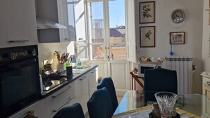 Une cuisine comprenant un coin repas, une cuisinière, des placards et une fenêtre.