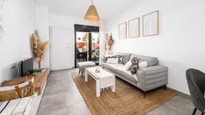 A modern living room with a grey sofa, white coffee table, and a hanging light fixture. - Benoa Zen Ground-floor luxury, direct pool access, by Oyoostays (Pilar de la Horadada)