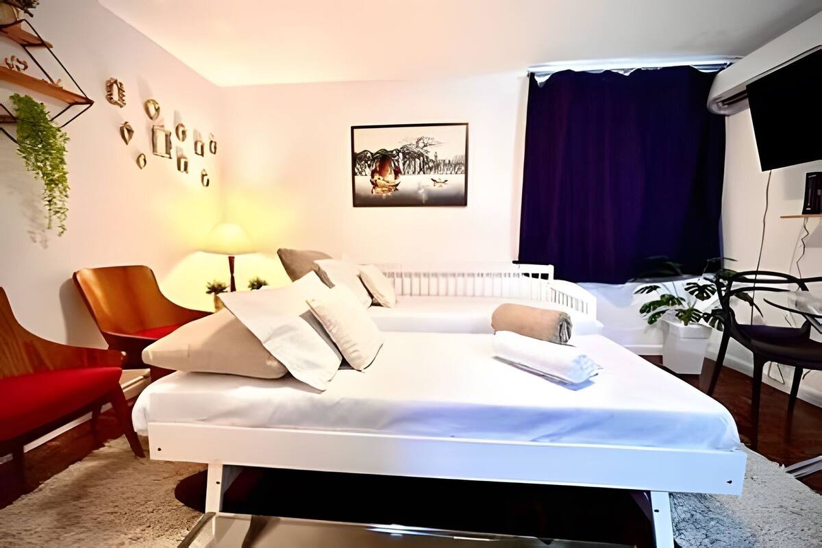 A neatly arranged bedroom with a bed, a chair, a desk, a lamp, and a picture on the wall.