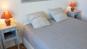 A bedroom with a bed, two bedside tables, a nightstand, a mirror, and two lamps. - Detached house 90m south facing for 6 people with air conditioning (Bauduen)
