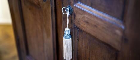 A wooden door with a metal keyhole and a decorative keychain.