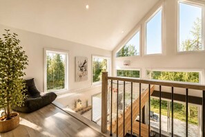 A spacious balcony with a wooden railing, a cushioned seating area, and a potted plant. - Spa | Relaxation Net | Le Dormëa (Saint-Côme)