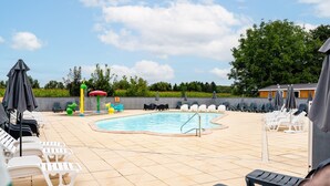 A pool area with lounge chairs, umbrellas, and a swimming pool.