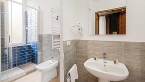 Un bagno con bidet, lavandino e specchio.