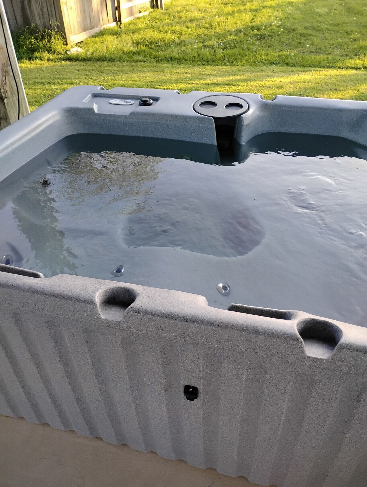Un jacuzzi con asiento incorporado y panel de control.