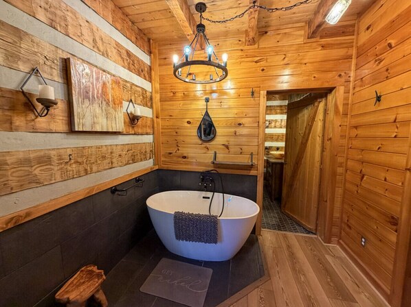 A wooden cabin bathroom with a freestanding bathtub, a chandelier, and wooden walls. - Boujee Bear- Modernized Cabin Minutes to Dollywood (Sevierville)