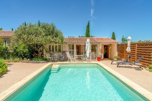 A swimming pool with lounge chairs, a table, and a covered area with umbrellas. - Cottage 'La Petite Cadenelle' with Private Pool, Wi-Fi and Air Conditioning (Eygalières)