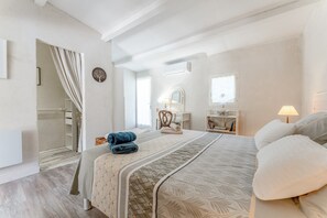 A bedroom with a bed, a bedside table, a mirror, a window, and a wardrobe. - Cottage 'La Petite Cadenelle' with Private Pool, Wi-Fi and Air Conditioning (Eygalières)
