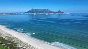 Eine Küstenlandschaft mit einem markanten Berg und einem Strand.