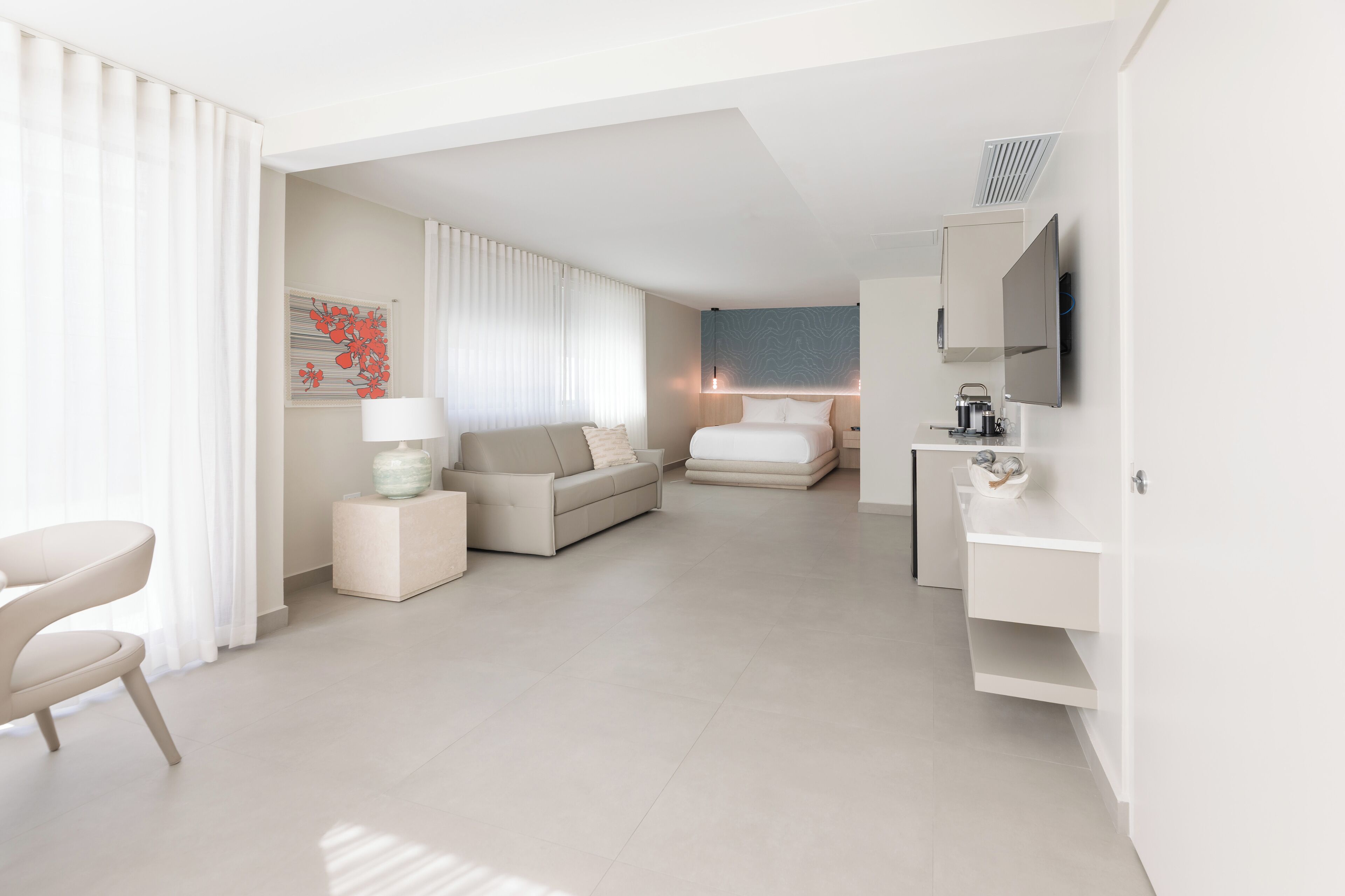Une chambre d’hôtel moderne équipée d’un canapé, d’un lit, d’un bureau et d’une télévision.