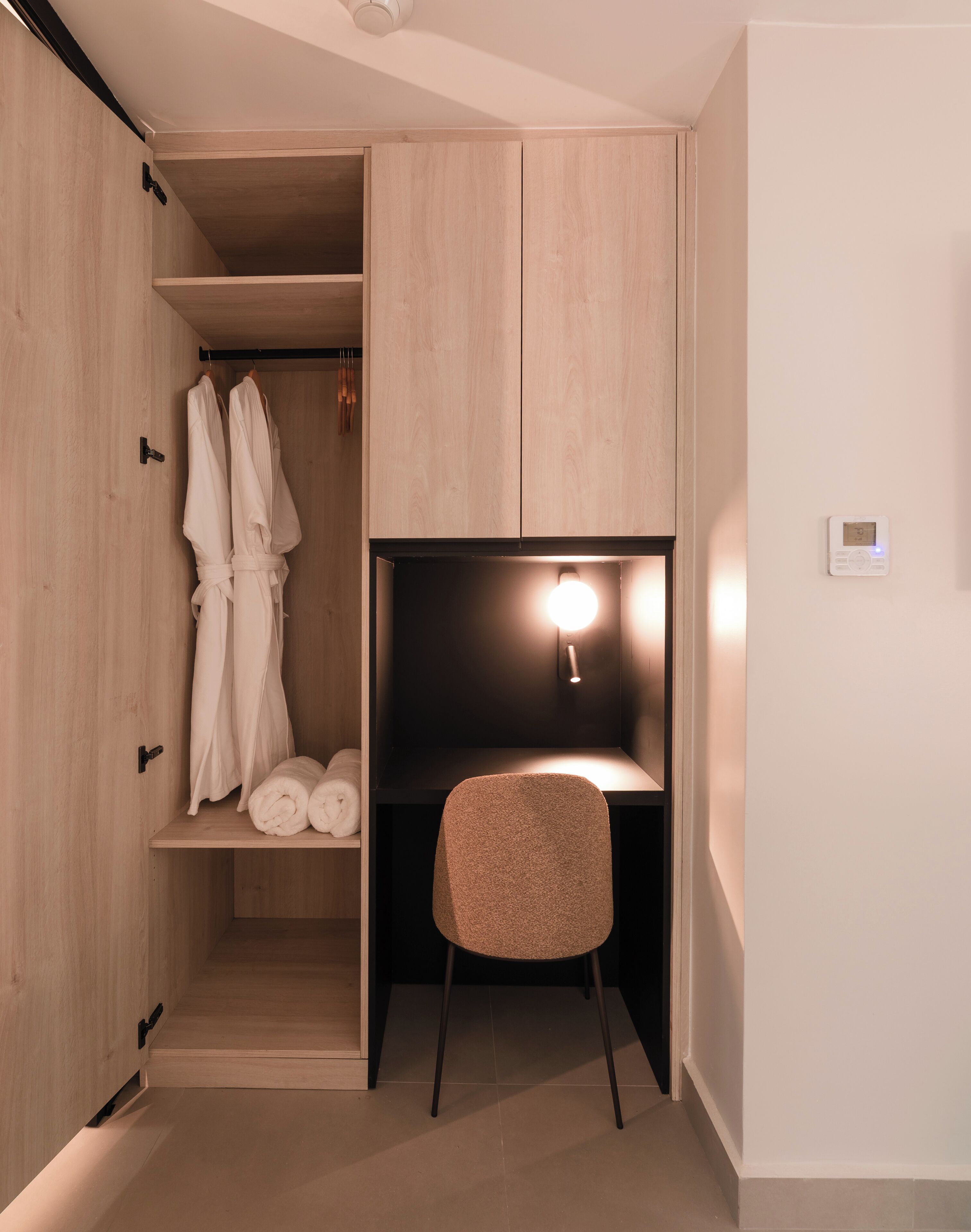 Un baño moderno con un mueble de tocador de madera, un perchero y una zona de ducha.