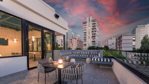 An outdoor terrace with a dining area, seating, and a cityscape view. - Magdalena 1163 (San Juan)