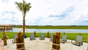 A beach area with a wooden fence, chairs, and a palm tree. - Last Minute Disney Getaway! Luxury Condo with Private Balcony. Book Now! #88033 (Orlando)