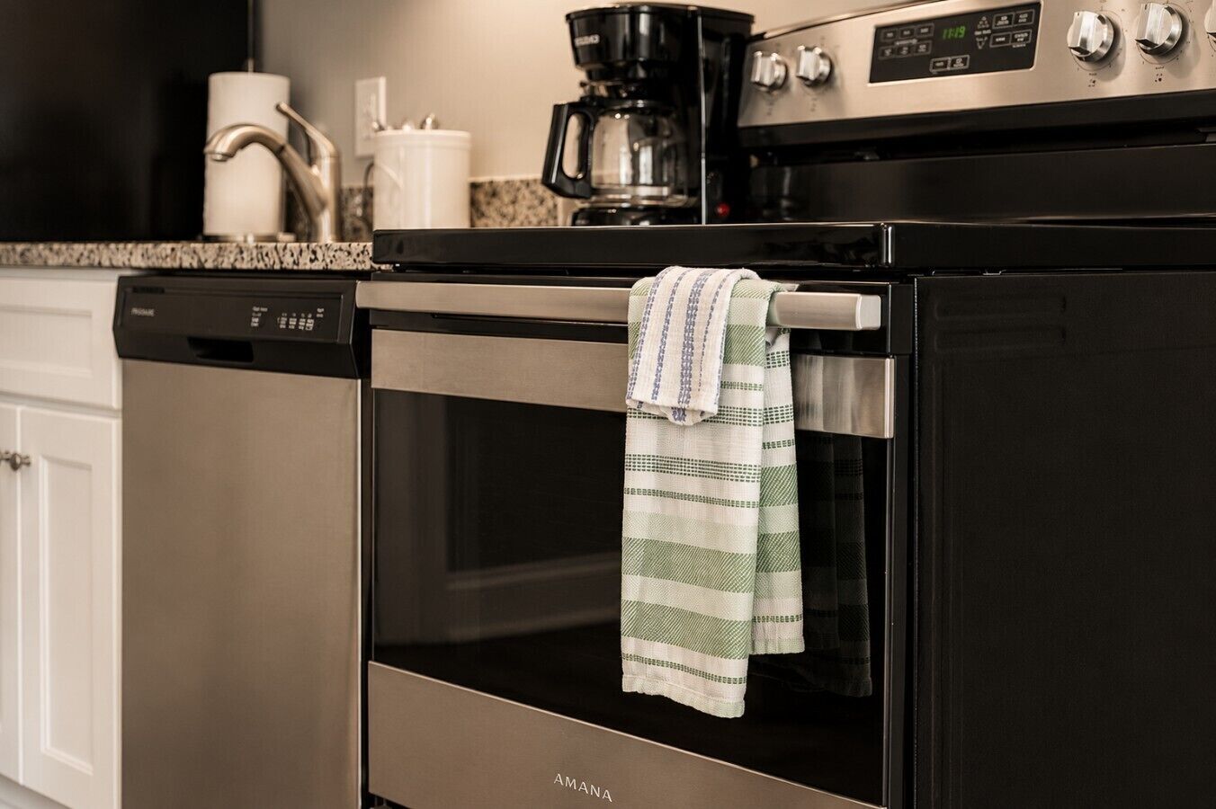 Una cucina con forno in acciaio inossidabile, una macchina da caffè e una lavastoviglie.