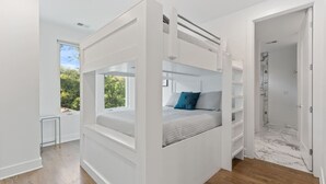 A modern bedroom with a bunk bed, a small window with a view of trees, and a walk-in closet. - King-bed home near East Nashville with easy access to local attractions (Nashville)