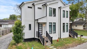 A two-story house with a front porch, a small tree, and a mailbox. - King-bed home near East Nashville with easy access to local attractions (Nashville)