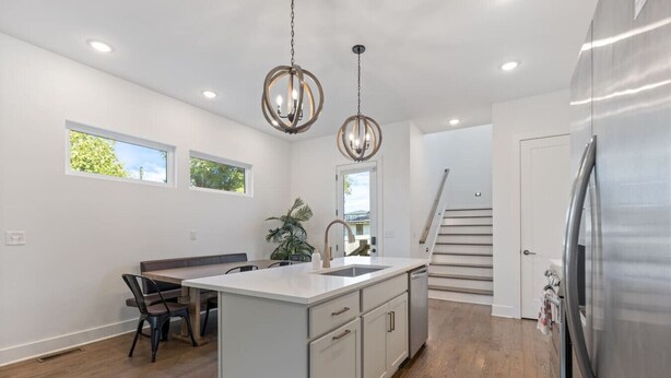 A modern kitchen with a central island, stainless steel appliances, and pendant lighting. - King-bed home near East Nashville with easy access to local attractions (Nashville)