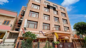 Un hotel a più piani con facciata in mattoni, numerosi balconi e un cartello che indica che si tratta di un albergo.