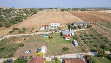 An aerial view of a residential area with houses, a grassy field, and a parked caravan.