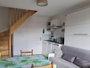 Ein kompakter Wohnbereich mit einer Küche, einem Essbereich und einem Sofa.