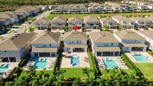 A residential area with multiple houses, a central swimming pool, and a red location marker. - Last Minute Disney Getaway! Luxury Villa with Private Pool, Game Room & Themed Bedrooms. Book Now! #161617 (Orlando)