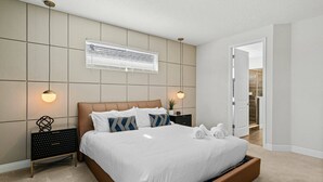 A modern bedroom with a large bed, bedside tables, and a wall-mounted light fixture. - Last Minute Disney Getaway! Luxury Villa with Private Pool, Game Room & Themed Bedrooms. Book Now! #161617 (Orlando)