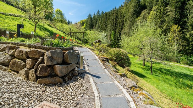 A stone pathway leading uphill with a wooden structure and a small shed in the background. - Apartment 'Rose' with Private Terrace, Shared Garden and Wi-Fi (Bad Peterstal-Griesbach)