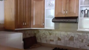 A kitchen with wooden cabinets, a gas stove, and a tiled backsplash. - Guest House Green Corner Supetarska Draga - Studio Apartment With Terrace And Sea View (Rab)