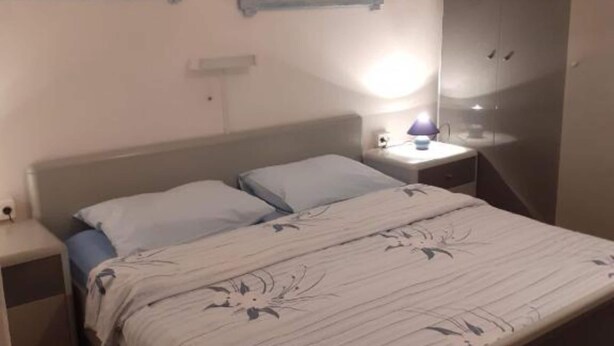 A bedroom with a bed, nightstand, and a mirror. - Guest House Green Corner Supetarska Draga - Studio Apartment With Terrace And Sea View (Rab)