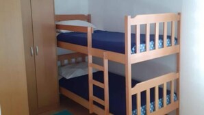 A bunk bed with a wooden frame and blue bedding, a wooden wardrobe, and a plain wall. - Guest House Green Corner Supetarska Draga - Studio Apartment With Terrace And Sea View (Rab)