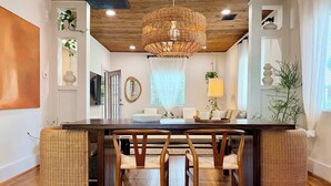 A dining area with a wooden ceiling, a woven light fixture, and a large window with curtains. - poolside getaway w/hot tub & relaxing courtyard (Houston)