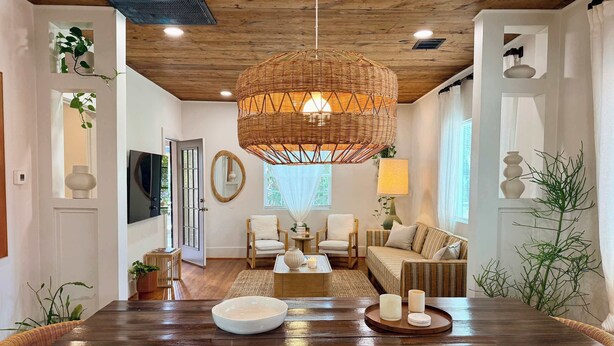 A spacious living room with a wooden dining table, two armchairs, a sofa, and a large woven light fixture. - poolside getaway w/hot tub & relaxing courtyard (Houston)