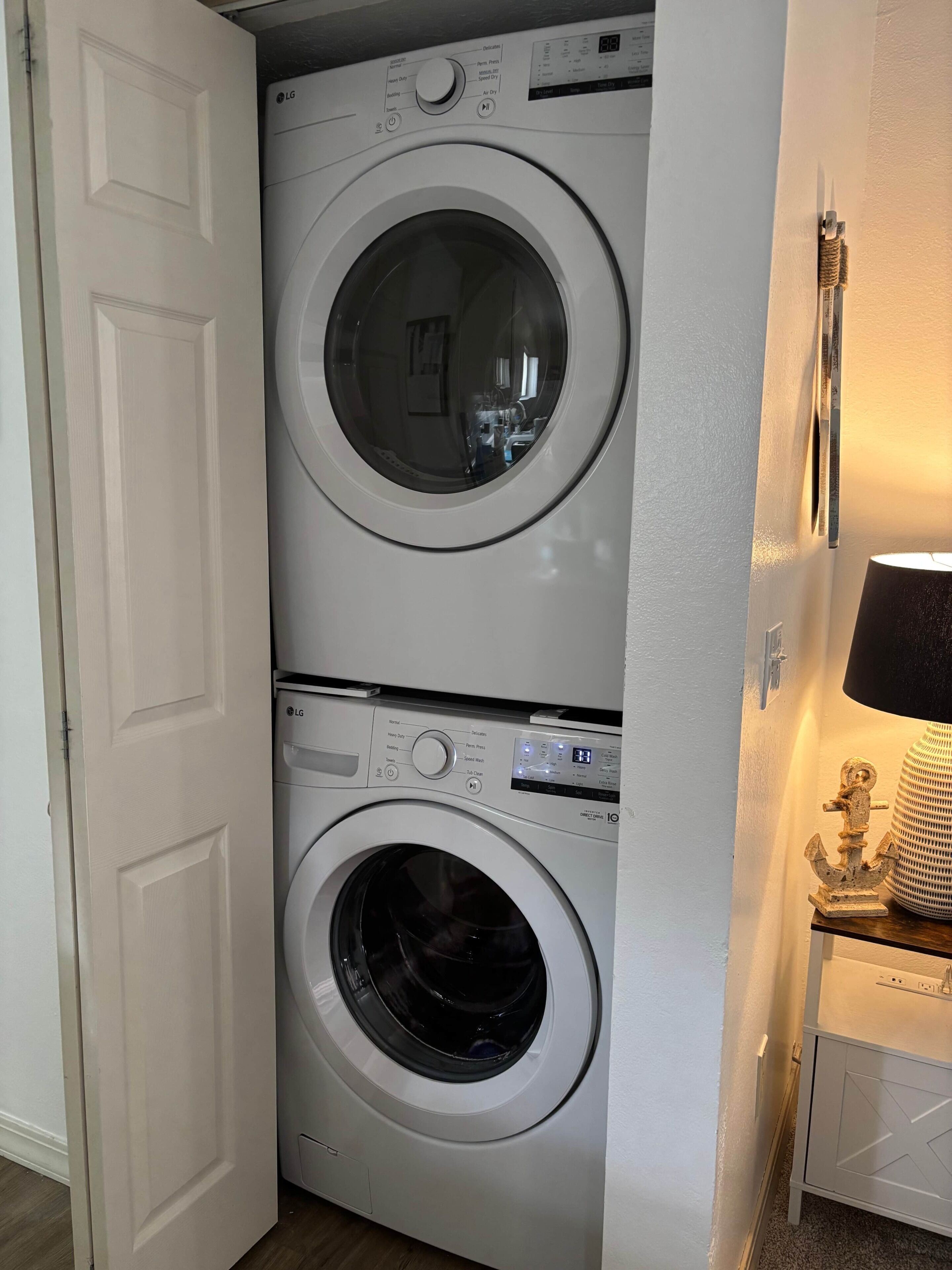 Uma lavanderia com duas máquinas de lavar roupa da LG, uma empilhada sobre a outra.
