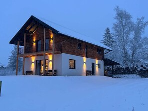 A two-story wooden house with a balcony, surrounded by snow-covered trees. - Alp Chalet Gundersheim (Gundersheim)