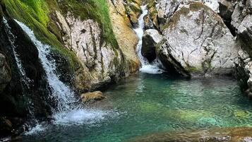 A natural water feature with a clear pool and a small waterfall.