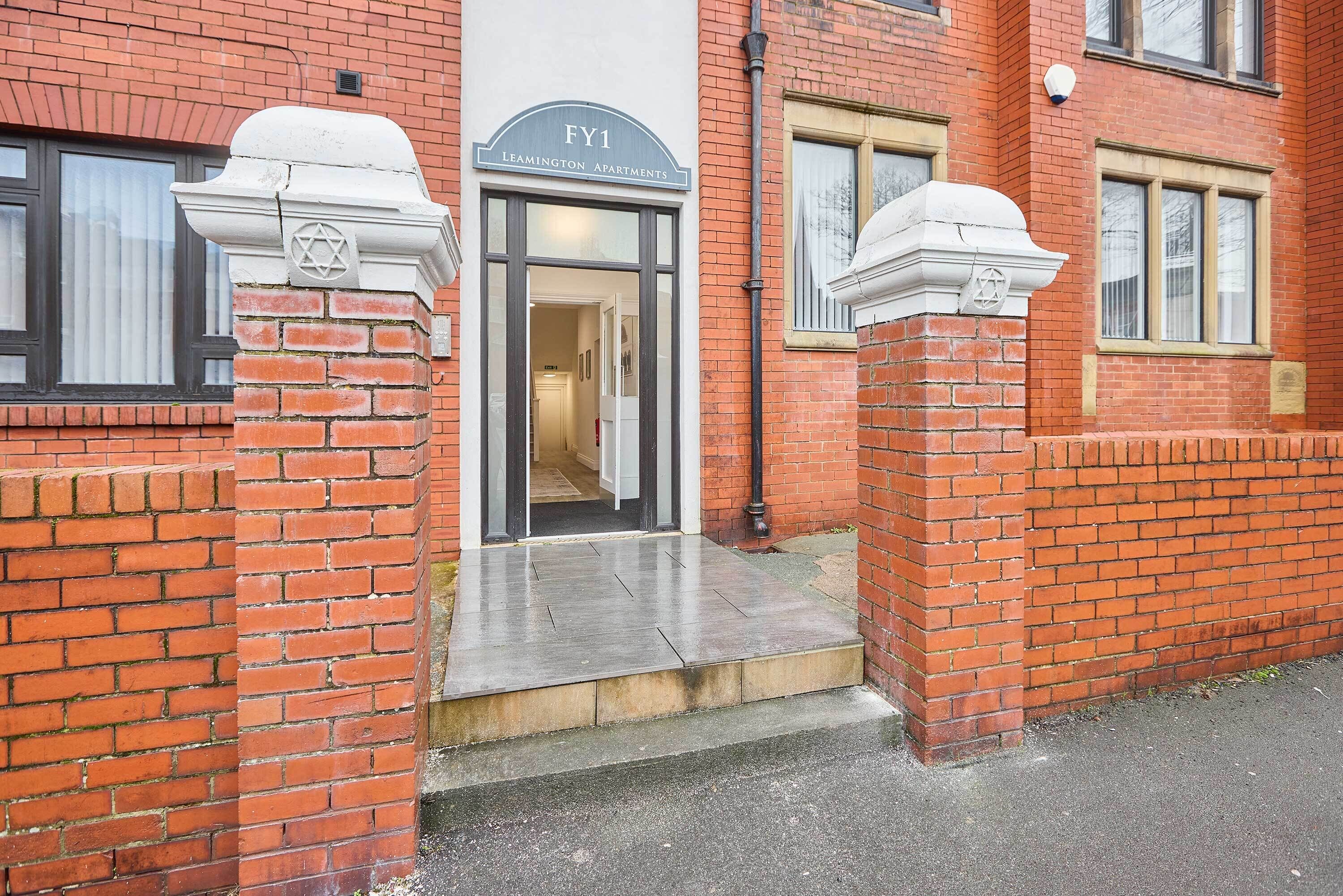 A brick building with a sign reading "FY1 Leamington Apartments".