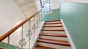 Una escalera con peldaños de madera y barandillas de metal.