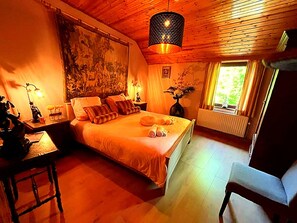 A cozy bedroom with a large bed, a desk, and a chair. - Dog-friendly Home With Bubble Bath (Bouillon)