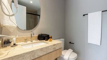 A bathroom with a sink, mirror, towel rack, and toilet.