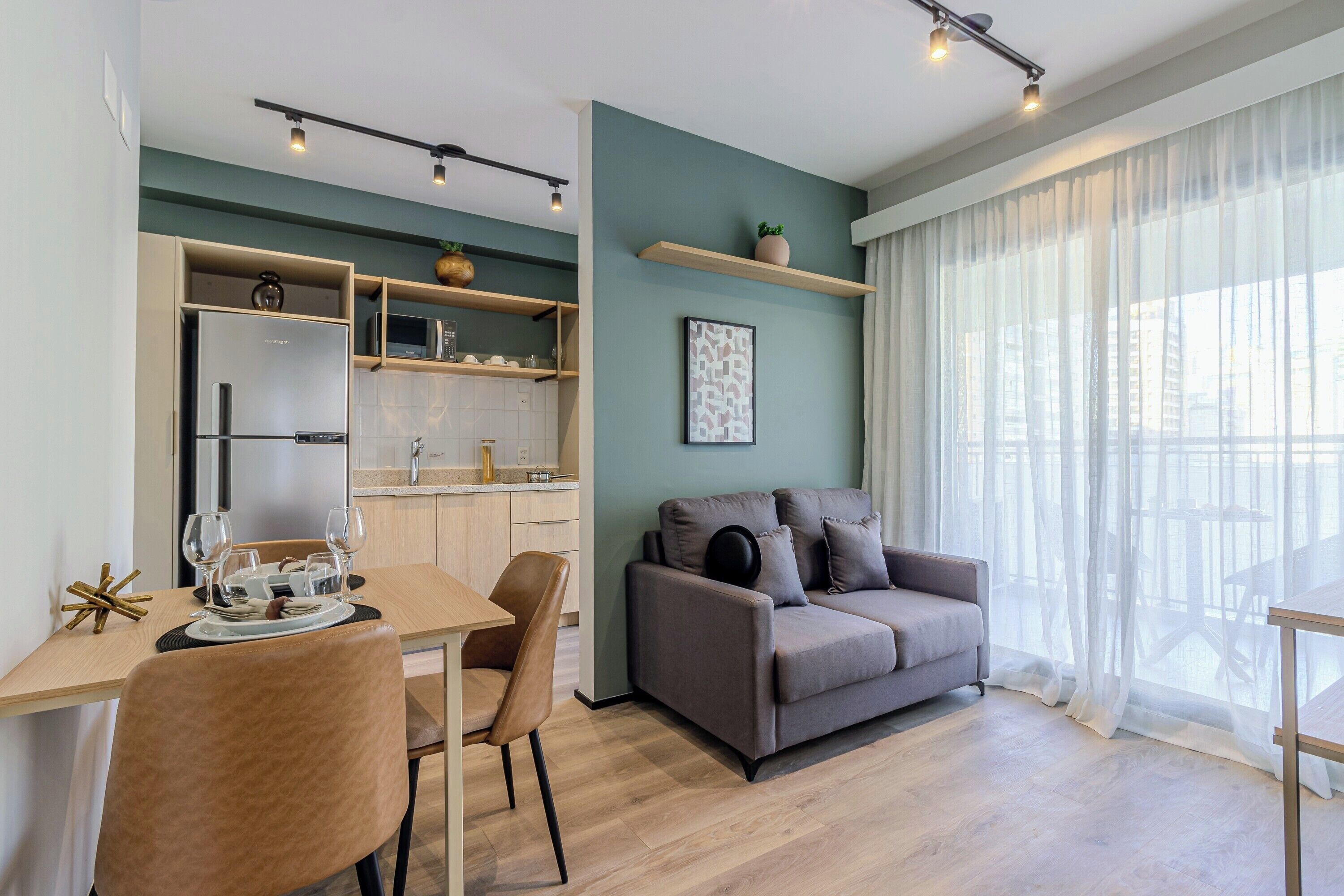 Een moderne woonruimte met een eethoek, kitchenette en een zithoek.