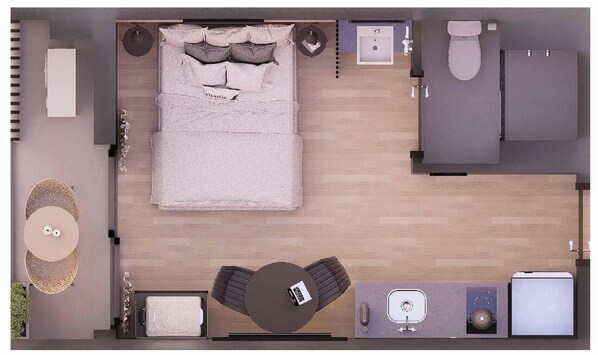 Vista cenital de una habitación de hotel con cama, una pequeña zona de estar, kitchenette, baño y una mesa de comedor.