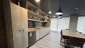 Een moderne keuken met een houten aanrecht, inbouwmeubels en een eethoek met tafel en stoelen.