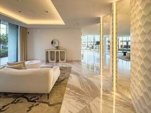 Une chambre d’hôtel moderne avec un grand lit, une petite table de chevet et une vue sur l’espace extérieur.