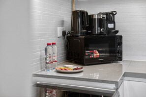 A kitchenette with a microwave, coffee maker, and water bottles. - Spa / Gym / Sea View / High Floor / Marina Walk (Dubai)